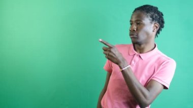 Man points corner of screen, black teenager pointing to the corner side of the screen with his left hand, show body language and facial expressions in front of a green screen