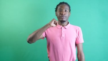 Black man making won sign, man making a win sign making a fist with one hand, show body language and facial expressions in front of a green screen