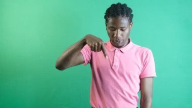 Black man pointing finger down, young black man pointing to the bottom of the screen with his left hand, show body language and facial expressions in front of a green screen