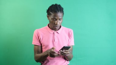 Come across something bad on phone, black man upset by the news he got from the phone, show body language and facial expressions in front of a green screen