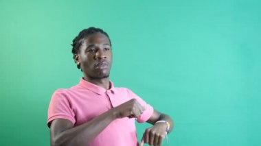 Young man dancing cheerfully, black male showing dance moves, dancing with gestures, show body language and facial expressions in front of a green screen