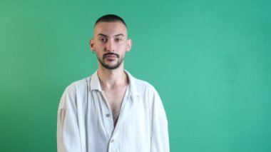 Man making sign of stop, male model raising left hand showing no-pass sign, emotions and facial expressions of the model in front of the green screen