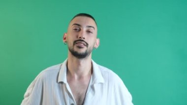 Disregardful facial expression, facial gestures of male model rudely chewing gum, facial expressions image taken portrait in front of green screen