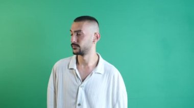 Thoughtful facial expression, Image of young male thoughtfully putting his hand to his head, image of emotions and facial expressions taken in front of the green curtain