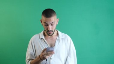 Man staring at the phone, The man who was very surprised by the news he got from the phone, emotions and facial expressions of the model in front of the green screen
