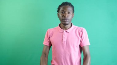 Black young showing victory, making the winning sign with both hands, fists as a sign of strength, show body language and facial expressions in front of a green screen