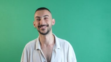 Mutlu adam yüzü, gülümseyen genç adam, hoş yüz ifadesi, yeşil ekranın önünde çekilmiş yüz ifadeleri.
