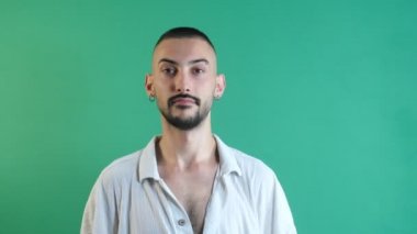 Köşeyi gösteren adam, sağ köşeyi iki eliyle gösteren adam, yüz ifadeleri görüntüsü yeşil ekranın önünde çekilmiş.