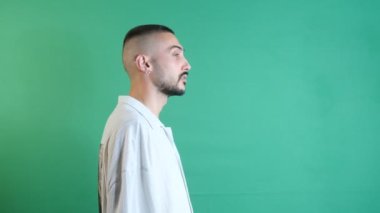 Man looking someone around, facial expression looking for someone with ones eyes, emotions and facial expressions of the model in front of the green screen