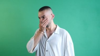 Kötü kokan bir adamın yüz ifadesi, kötü kokuyu bastıran yüz ifadeleri, yeşil ekranın önünde vücut dilini ve yüz ifadelerini gösterme.