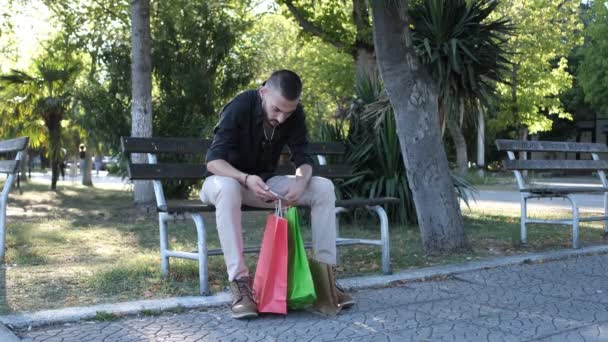 Man Looking Shopping Bags Young Man Sitting Resting His Bags — Wideo stockowe
