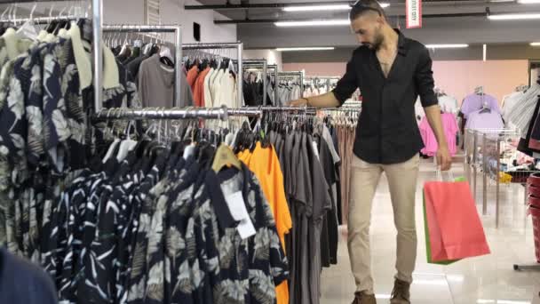 Man Looking Shirt Store Young Man Examining Shirts Aisle Image — Wideo stockowe