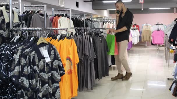 Чоловік Йде Покупками Подобається Продукт Поміж Футболок Покупки Магазині Одягу — стокове відео