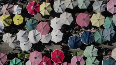 Drone footage of shopping markets set up on the street, street shopping covered with umbrellas and tents, shopping tents set up on the road between the apartments