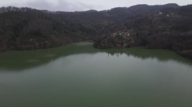 The images of dam lake waters accumulated in the valley in the forest, drone view of the hydroelectric power plant lake, dam lake surrounded by green forests