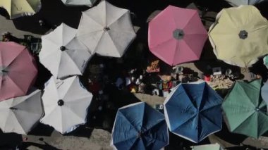 Drone footage of shopping markets set up on the street, street shopping covered with umbrellas and tents, shopping tents set up on the road between the apartments