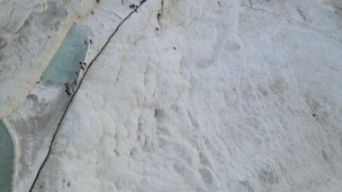 Drone view of Pamukkale travertines, natural beauty consisting of waterfalls and swimming pool with white minerals in Turkey