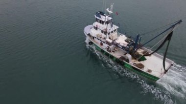 Drone footage of white fishing boat in the middle of the sea, fishing with nets, fishing seafood, white boat in the lake