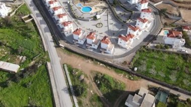 Aerial drone view of the popular holiday sites of Kyrenia, the view of the swimming pool and the hotel garden between the trees, housing estate of cyprus