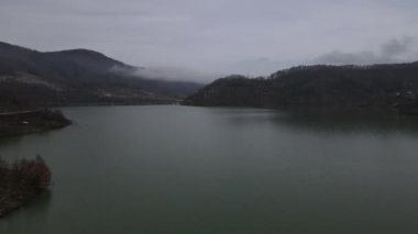 The images of dam lake waters accumulated in the valley in the forest, drone view of the hydroelectric power plant lake, dam lake surrounded by green forests