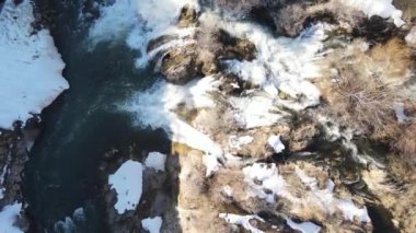 Drone view of the water flowing through the stones in the autumn season, the beauty of the water flowing from the waterfall in the streambed