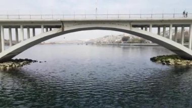 River and bridge view taken under the bridge shoot by drone, The view of the bridge built on the creek, the traffic of the vehicles crossing the bridge
