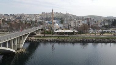 Drone view of the city located by the Euphrates river, bridge over the river and public parks by the river