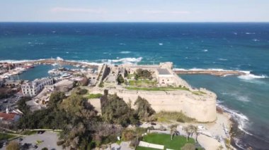 Drone view of the historical Kyrenia castle built by the sea, the walls of the historical castle made of stone, the historical beauties of the city of Kyrenia near the sea
