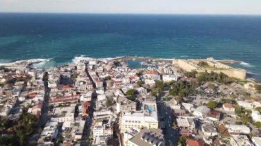 Drone view of the magnificent seaside city, the seaside where the foamy waves hit the shore, the castle of girne near by the sea in cyprus