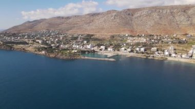 The harbor view of the coastal city established at the foot of the mountain, the view of the sea and the mountain, the ships anchored in the harbor and the city settlement