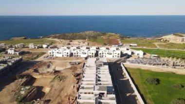 Aerial drone view of the holiday site construction in Kyrenia seaside, concrete works of the construction company, holiday site construction site view near by the sea