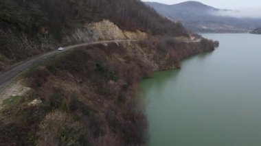 The images of dam lake waters accumulated in the valley in the forest, drone view of the hydroelectric power plant lake, dam lake surrounded by green forests