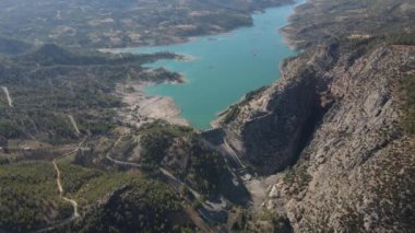 Drone view of dam water collected in the valley hydroelectric power plant from renewable energy sources, power plant in the mountains