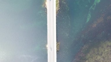 Drone view of vehicles passing over the bridge built on the river, transportation on the stream, traffic on the bridge