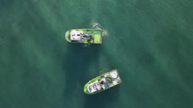 Aerial drone view of the white ship fishing in the lake, fishermen in the waters when the season starts, fishermen hunting in the middle of the sea