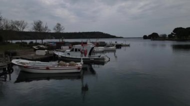 Image of small boats moored in the bay, fishing boats not working in winter, disused boats moored in water in autumn