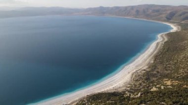Drone view of volcanic lake Salda lake surrounded by mountains, tectonic lake famous for its white sandy beach and turquoise waters, magnificent beauty of nature lake salda