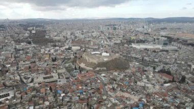 Drone view of the castle built in the middle of the city, historical heritage of the city of Gaziantep between buildings and apartments, historical medieval castle