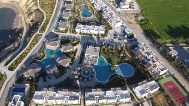 Drone view of holiday site in cyprus, water pools and entertainment venues and hotels for summer vacation near by the sea in cyprus