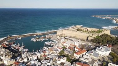 Drone view of the historical Kyrenia castle built by the sea, the walls of the historical castle made of stone, the historical beauties of the city of Kyrenia