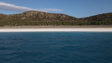 The view of Salda Lake is famous as a crater lake against the mountain, drone view of Salda Lake with its white sandy beach and turquoise waters, Turkeys volcanic lake region