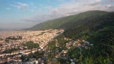 Aerial city built on mountain, drone view of the city settled on the mountainside, urban view of apartments and buildings