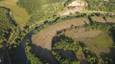 Curvy green land, rural areas where the meandering stream passes, green village fields, settlement of villages and cultivation land