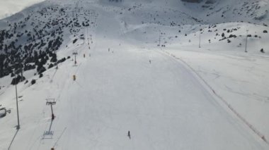 Doğal buz pateni pistinde kayak yapan insanların insansız hava aracı görüntüsü, erzincan ergan kayak merkezinde kış tatilcileri, yolda kayak yapan turistler.
