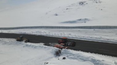 Kar yağışı sonrası güneşli bir günde kar temizlemeye çalışan kar küreme aracının hava görüntüsü, taşımacılık için çalışan kar küreme araçları, Kars Turkey 