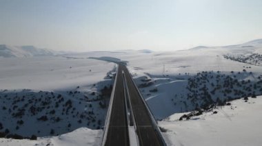 Karlı bir kış günü otoyol köprüsünün havadan görünüşü, dağlardan geçen insansız hava aracı otoyol köprüsü, Kars Türkiye 