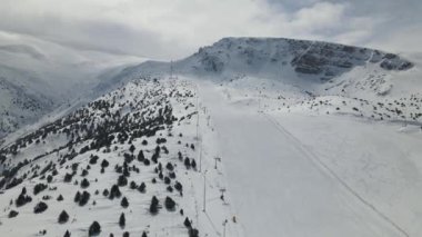 Dağın yamacına kurulan karla kaplı kayak merkezinin insansız hava aracı görüntüsü, Türkiye 'nin yer aldığı Ergan kayak merkezi olan dağın eteklerine yerleşti.