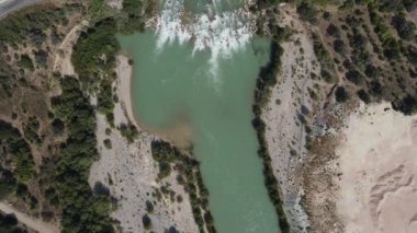 Doğada akan hava suyu, geniş ovalarda akan nehir yolu drone manzarası, nehir kenarındaki yeşil tarım arazisi habitatı.