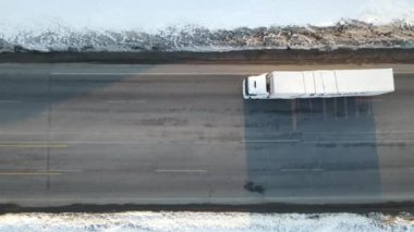 Karlı yoldan geçen kargoyu taşıyan kamyonun görüntüsü, kışın karlı yolda giden kamyonun görüntüsü.
