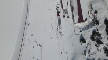 Yüksek dağlar arasındaki kayak merkezinin havadan görünüşü, insansız hava aracı görüntüsü kayak yapan insanlar ve teleferik taşımacılığı yapan Ergan Dağı Türkiye 